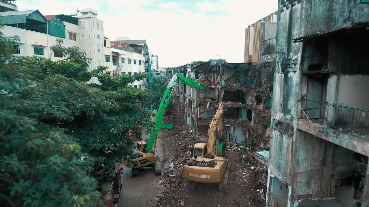 Frame real da obra mostrando máquinas executando demolição em campo